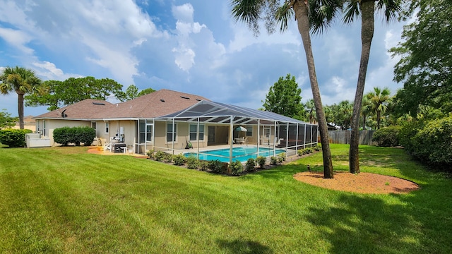 back of house with a lawn, a lanai, a fenced in pool, and a patio area