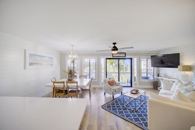 living room with light hardwood / wood-style flooring and ceiling fan with notable chandelier