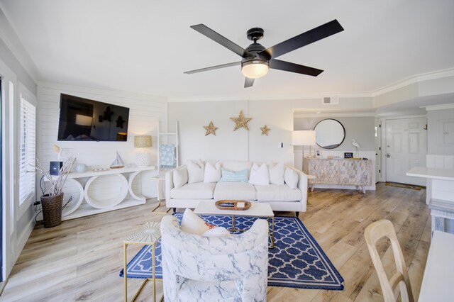 living room with ceiling fan, crown molding, and light hardwood / wood-style floors