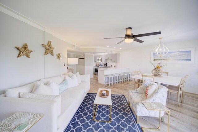 living room featuring light wood-type flooring, crown molding, and ceiling fan