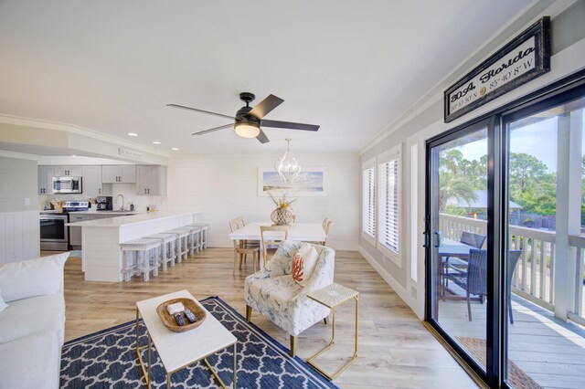 living room featuring sink, ceiling fan with notable chandelier, light hardwood / wood-style floors, and crown molding