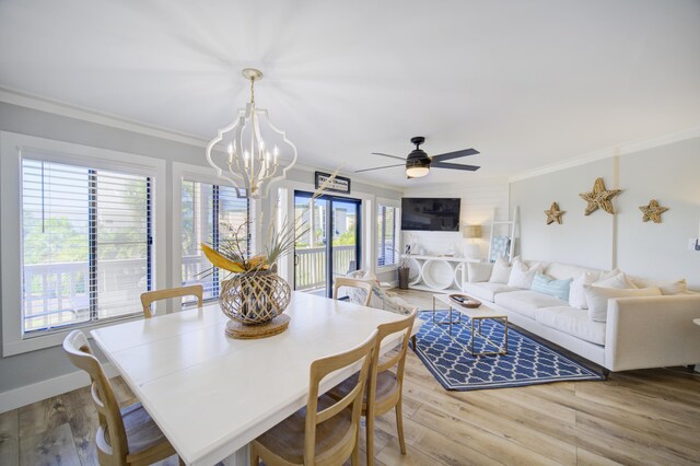 dining area featuring light wood-type flooring, ceiling fan with notable chandelier, and ornamental molding