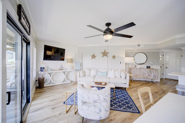 living room with ceiling fan, ornamental molding, and light hardwood / wood-style floors