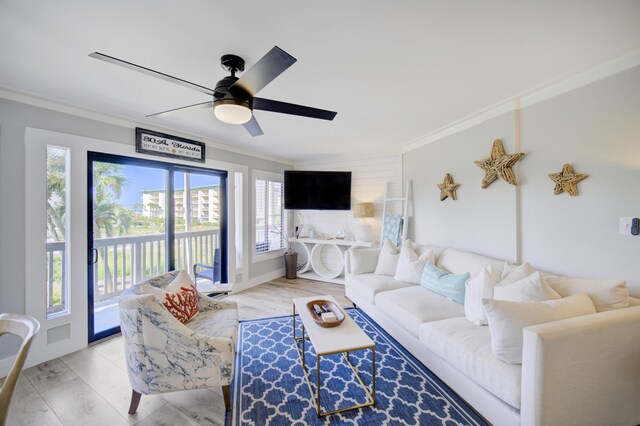 living room featuring ceiling fan, light hardwood / wood-style flooring, ornamental molding, and a healthy amount of sunlight