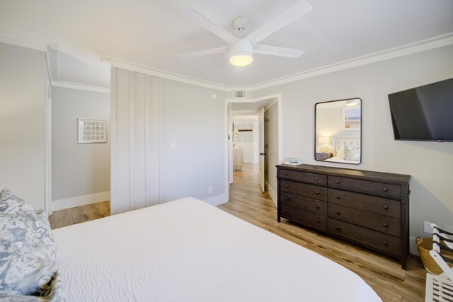 bedroom with ceiling fan, ornamental molding, and light hardwood / wood-style floors