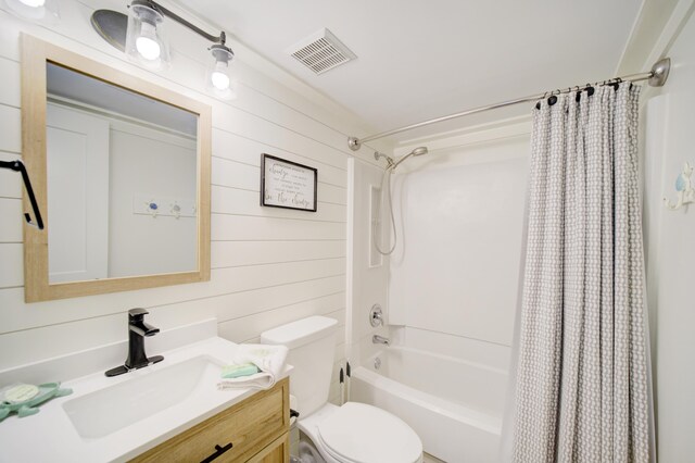 full bathroom with shower / bath combo with shower curtain, vanity, wooden walls, and toilet