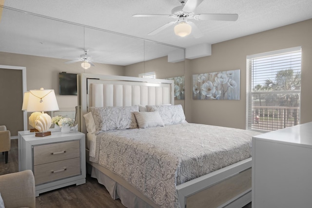 bedroom featuring dark wood-style floors, ceiling fan, and a textured ceiling