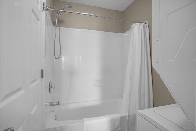 bathroom with a textured ceiling, shower / tub combo, and washer / clothes dryer