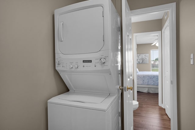 washroom with laundry area, stacked washing maching and dryer, and wood finished floors