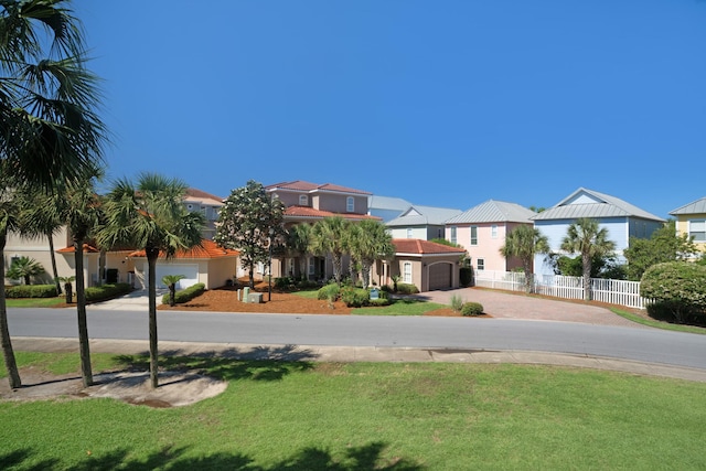 view of front of home with a residential view, fence, a front lawn, and stucco siding