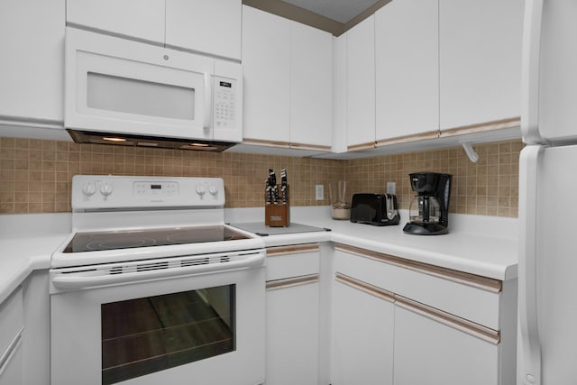 kitchen with white appliances, tasteful backsplash, white cabinets, and light countertops