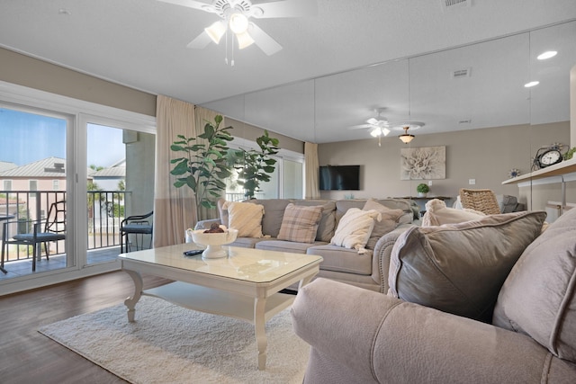 living room featuring ceiling fan, visible vents, and wood finished floors