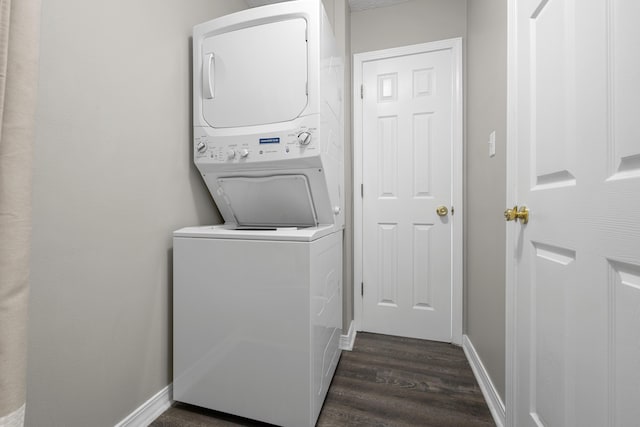 laundry area featuring stacked washer and dryer, laundry area, baseboards, and dark wood-style floors