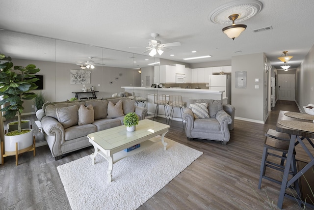 living area featuring dark wood-style floors, a textured ceiling, and visible vents