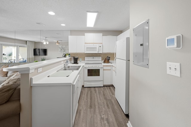 kitchen with white appliances, light countertops, a peninsula, and open floor plan