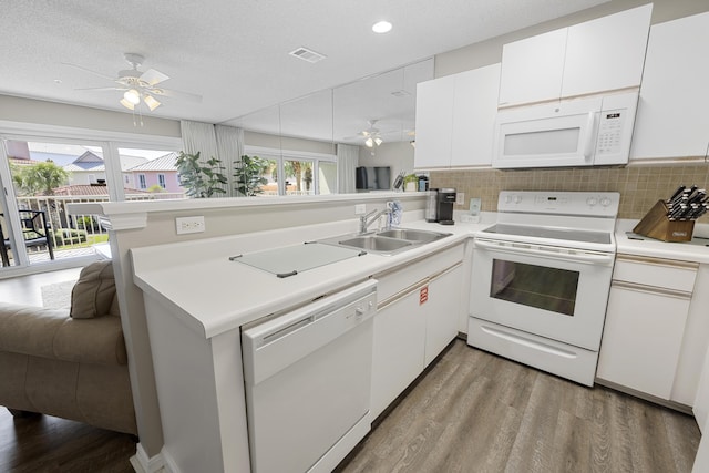 kitchen featuring white appliances, light countertops, a peninsula, and open floor plan