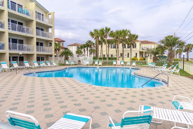 community pool featuring fence and a patio