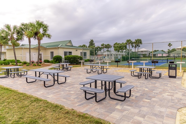 view of community featuring a residential view, a tennis court, and fence