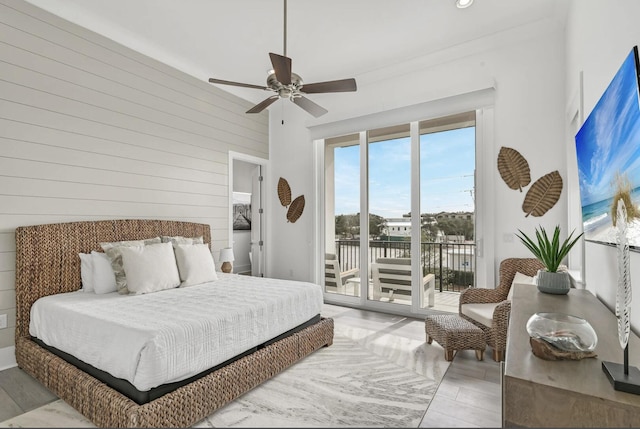 bedroom featuring access to outside, ceiling fan, and wood walls