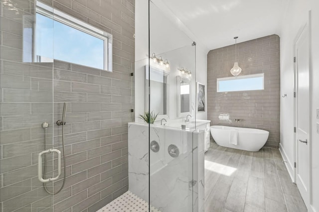 bathroom with vanity, independent shower and bath, and tile walls