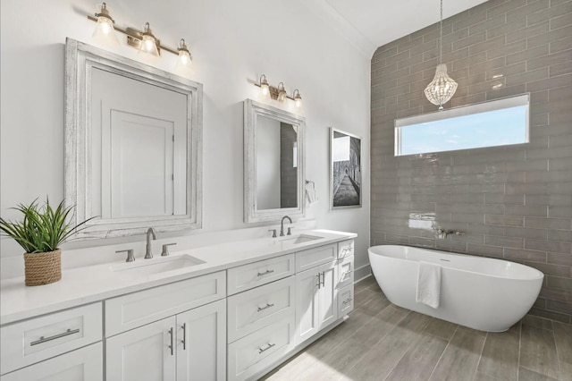 bathroom with hardwood / wood-style flooring, vanity, and a bathtub