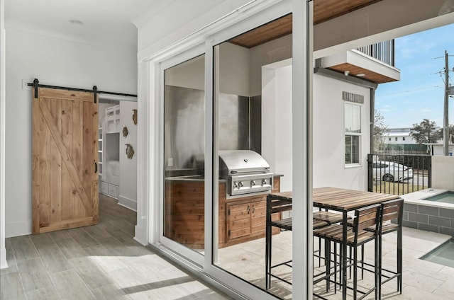 balcony with exterior kitchen, a grill, and a patio area