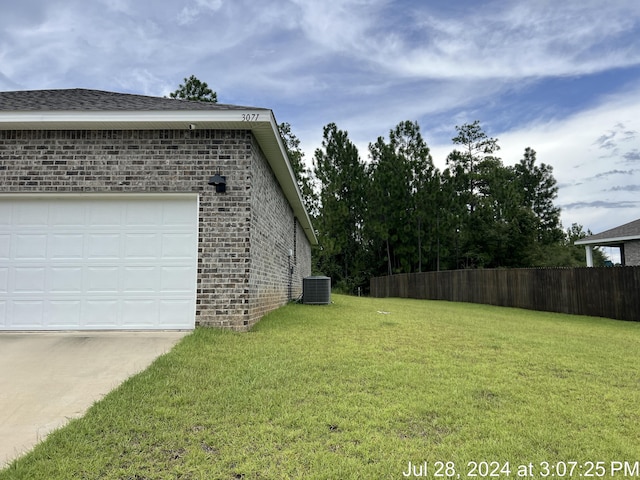 view of side of home with a yard, fence, and brick siding