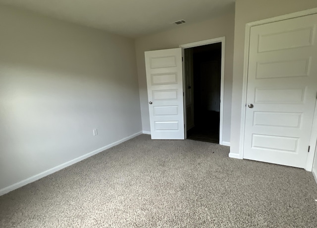 unfurnished bedroom with carpet, visible vents, and baseboards