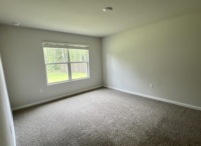 unfurnished room with carpet and baseboards