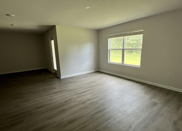 unfurnished room featuring dark wood-style floors and baseboards