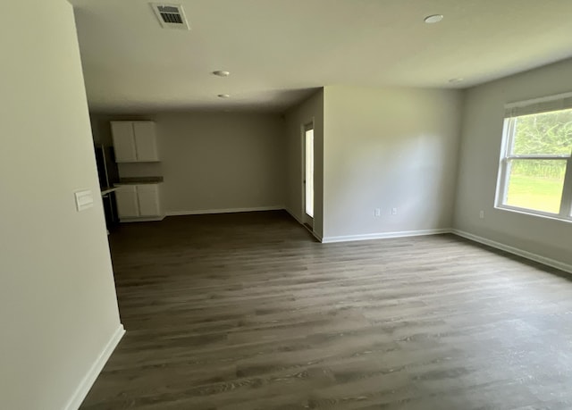 unfurnished room featuring visible vents, baseboards, and wood finished floors