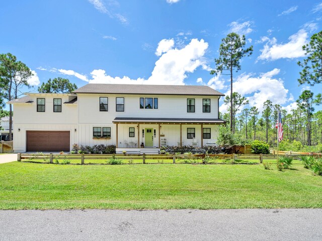 view of front facade with a garage, covered porch, and a front lawn