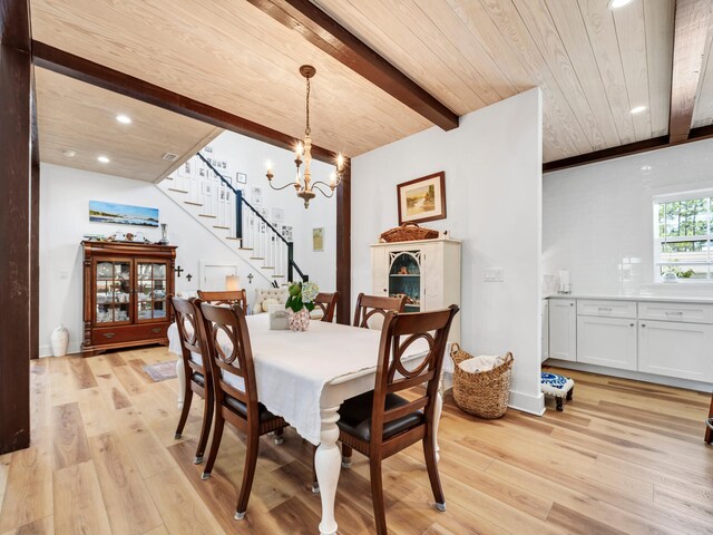 dining space featuring beamed ceiling, light hardwood / wood-style flooring, a chandelier, and wooden ceiling