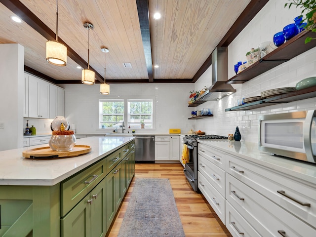 kitchen featuring appliances with stainless steel finishes, green cabinets, a kitchen island, white cabinets, and wall chimney range hood