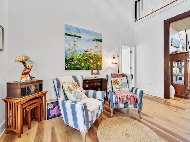 living area featuring hardwood / wood-style flooring and a high ceiling