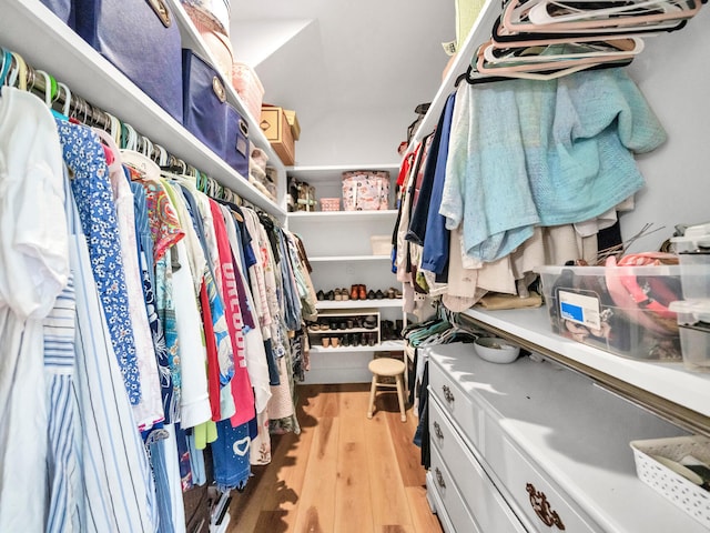 walk in closet with light hardwood / wood-style floors