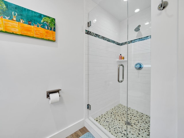 bathroom featuring hardwood / wood-style floors and a shower with shower door