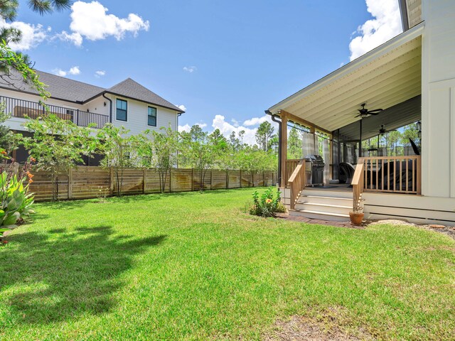 view of yard featuring a wooden deck and ceiling fan