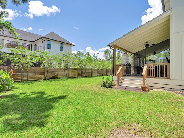 view of yard with a wooden deck and ceiling fan