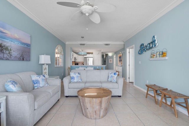 living room featuring light tile patterned flooring, a textured ceiling, ceiling fan, and ornamental molding