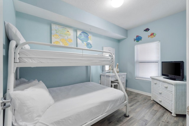 bedroom featuring a textured ceiling and wood-type flooring