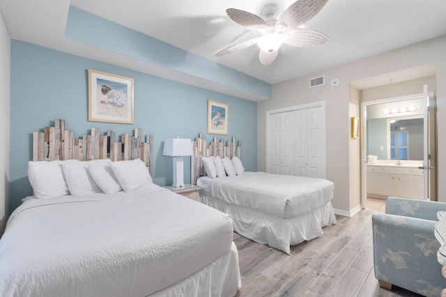 8573 Gulf Blvd Unit 703, Navarre, FL 32566 - bedroom with light wood-style floors, a closet, ensuite bathroom, a ceiling fan, and baseboards