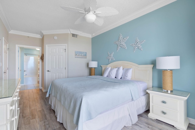 bedroom featuring ensuite bath, light hardwood / wood-style floors, crown molding, a textured ceiling, and ceiling fan