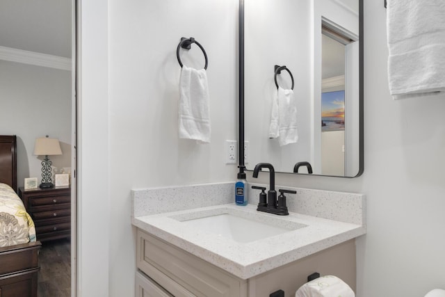 bathroom with crown molding, vanity, and wood-type flooring