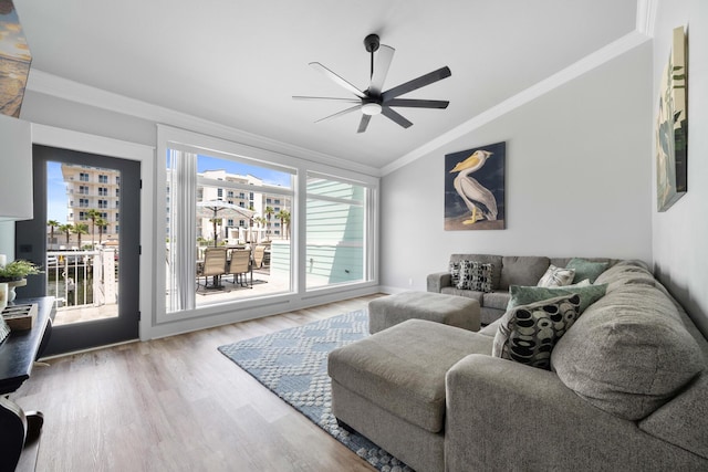 living room featuring crown molding, lofted ceiling, wood-type flooring, and ceiling fan