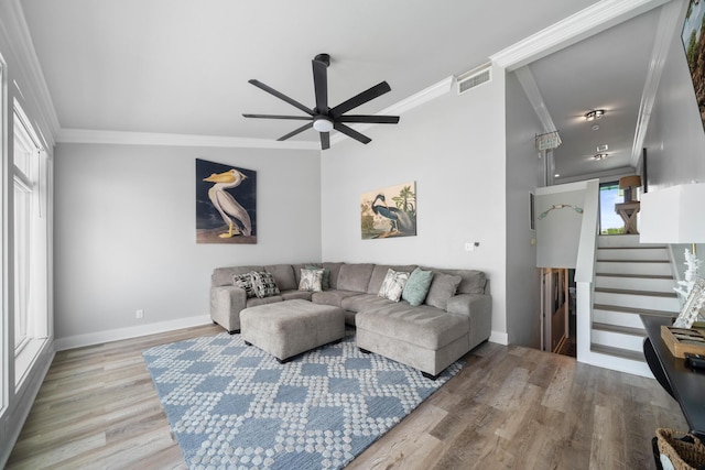 living room featuring ceiling fan, ornamental molding, and light hardwood / wood-style flooring