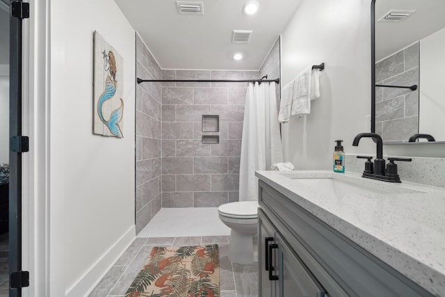 bathroom featuring walk in shower, vanity, and toilet