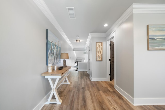 hallway with ornamental molding and hardwood / wood-style floors