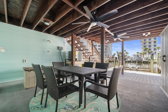 view of patio / terrace with a dock, ceiling fan, and a water view