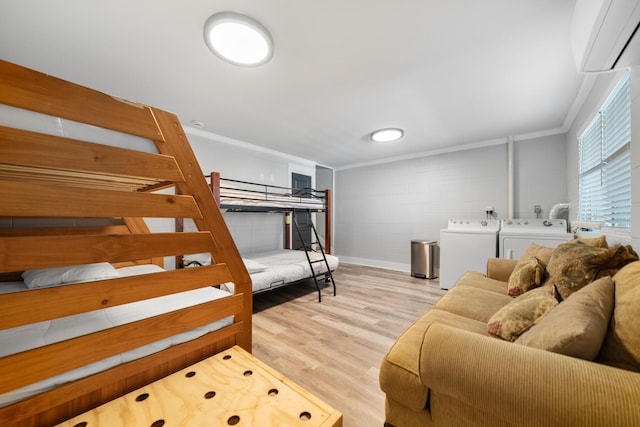 bedroom with ornamental molding, light hardwood / wood-style floors, and washer and dryer